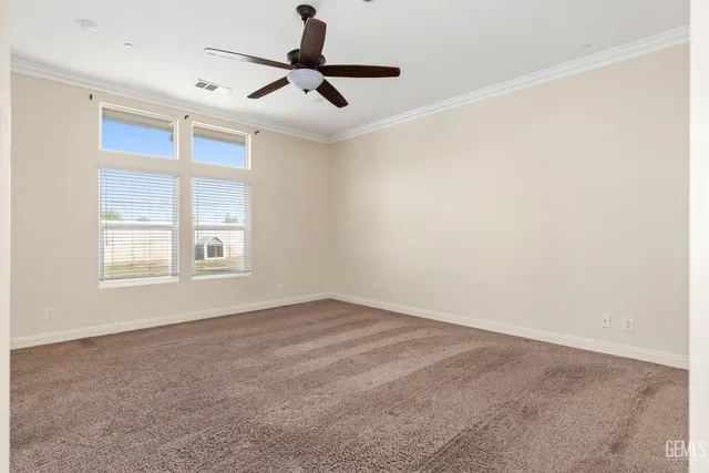 en empty room with windows and ceiling fan
