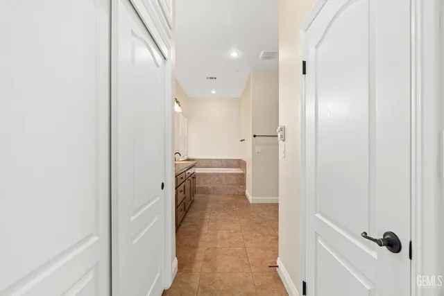 a bathroom with a granite countertop sink a light fixture and a mirror