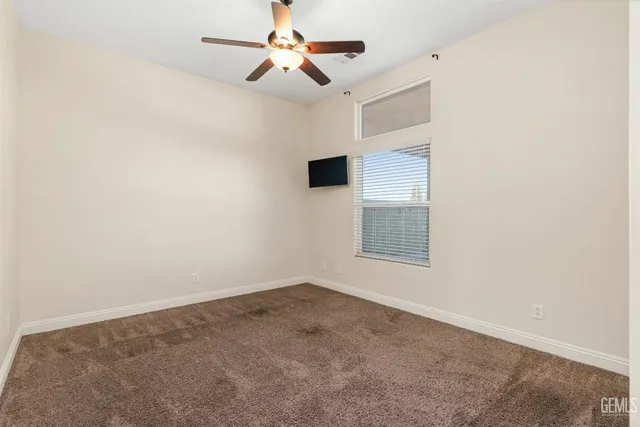 an empty room with chandelier fan