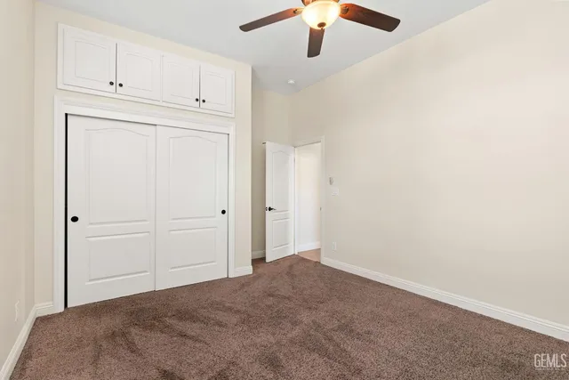 a view of an empty room with a ceiling fan