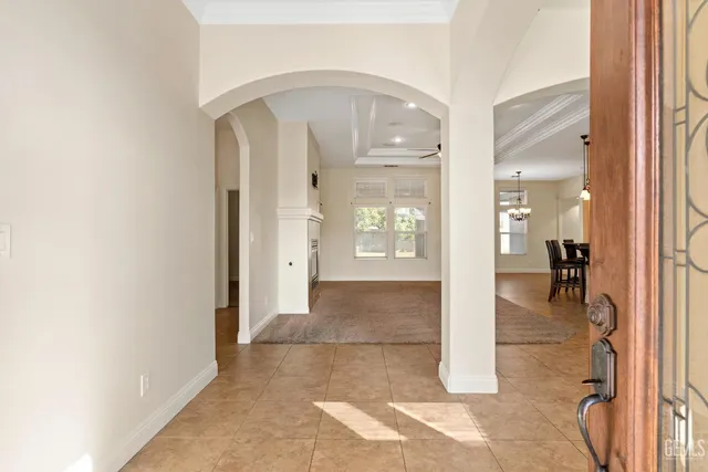 a view of a hallway with wooden floor and a living room