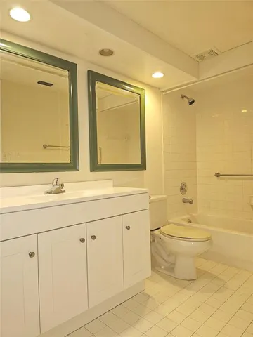a bathroom with a double vanity sink mirror and toilet