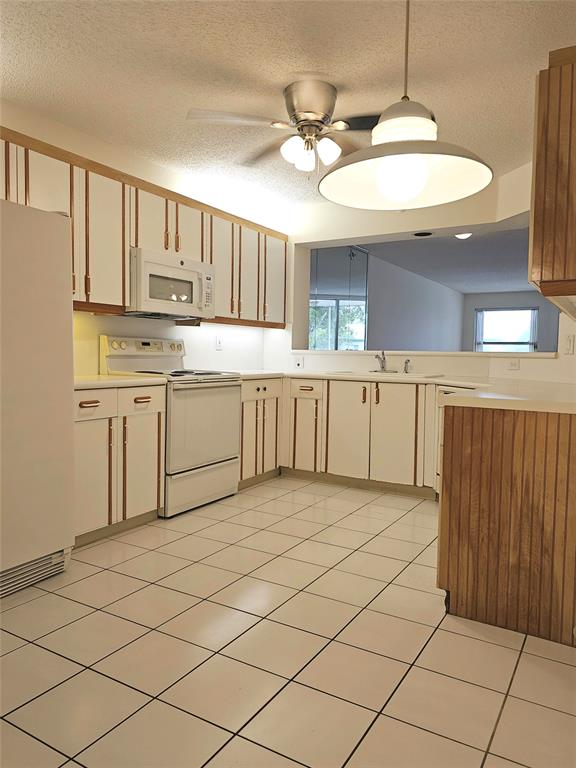 7843 Granville Drive, Unit 7843 Tamarac, FL 33321 - Photo 3 of 26 a kitchen with stainless steel appliances granite countertop a sink and cabinets