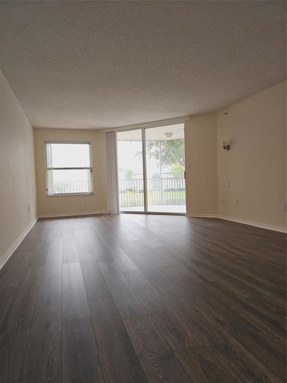 7843 Granville Drive, Unit 7843 Tamarac, FL 33321 - Photo 8 of 26 a view of an empty room with wooden floor and a window