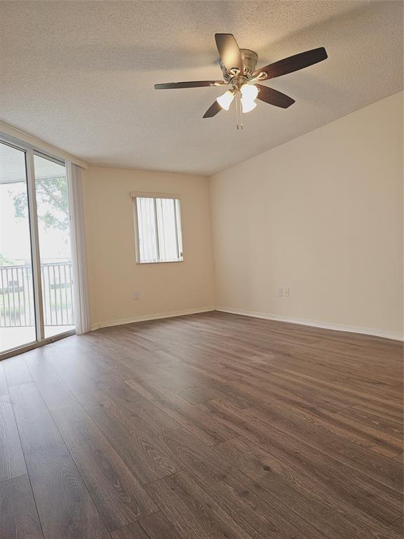 7843 Granville Drive, Unit 7843 Tamarac, FL 33321 - Photo 9 of 26 an empty room with wooden floor fan and windows