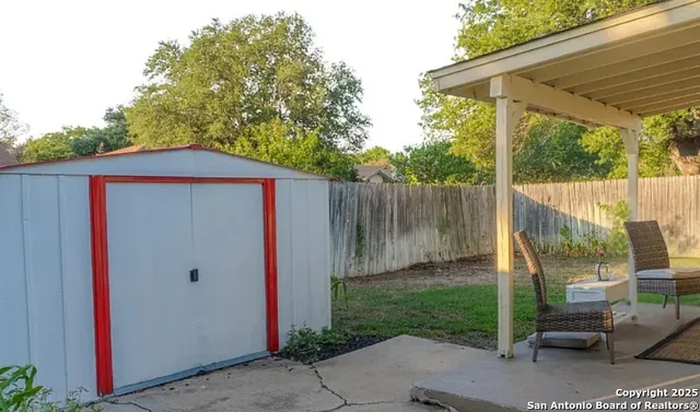 a backyard of a house with plants and wooden fence