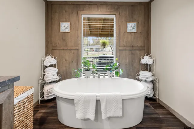 a white bath tub sitting in a bathroom next to a window