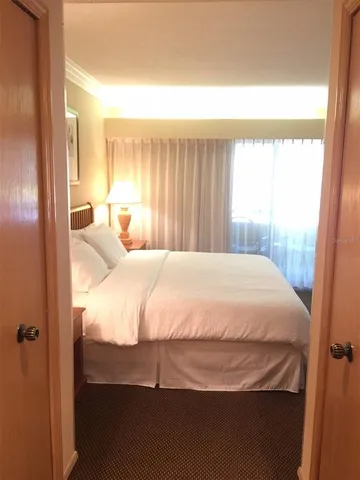 a large bed sitting in a bedroom next to a window