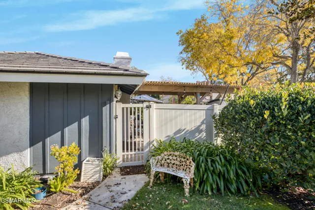 a view of a house with a small yard and a bench