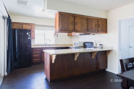 117 South Fire Opal Street Ridgecrest, CA 93555 - Photo 8 of 28 a kitchen with stainless steel appliances granite countertop a sink stove and refrigerator