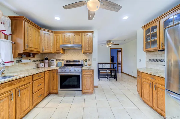 a kitchen with stainless steel appliances granite countertop a stove top oven a sink dishwasher and a refrigerator