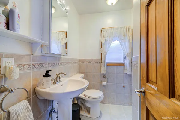 a bathroom with a sink a toilet and mirror
