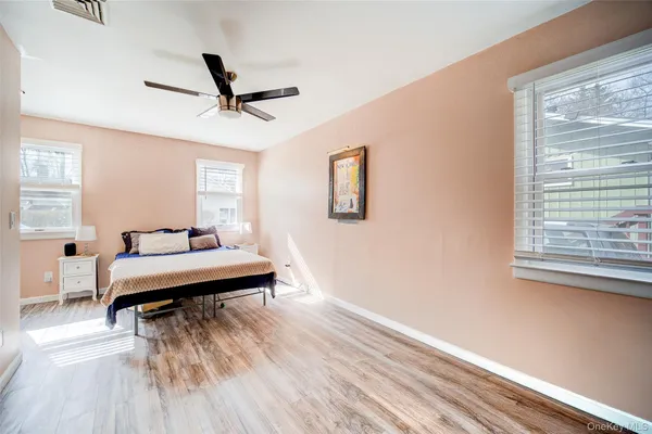 a bedroom with a bed and a wooden floor