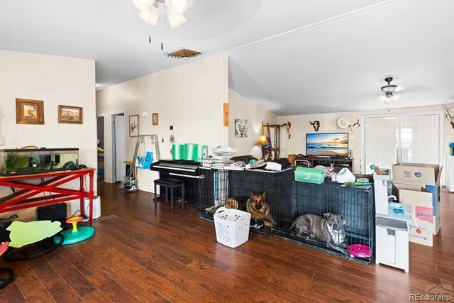 a living room with furniture kitchen view and a wooden floor