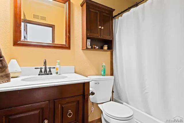 a bed room with a bed window and painting on the wall