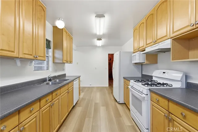 a kitchen with stainless steel appliances a sink a stove and cabinets