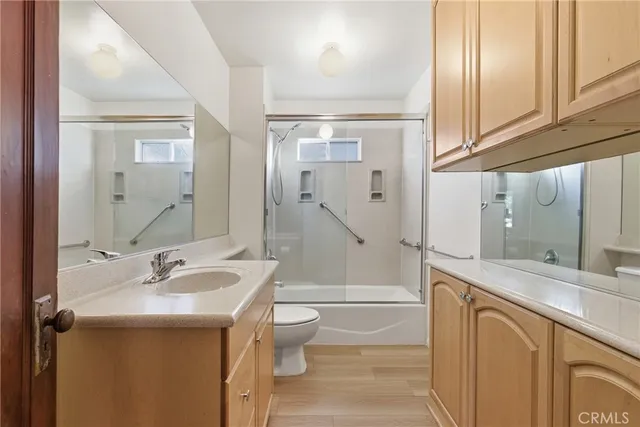 a bathroom with a granite countertop sink toilet and shower