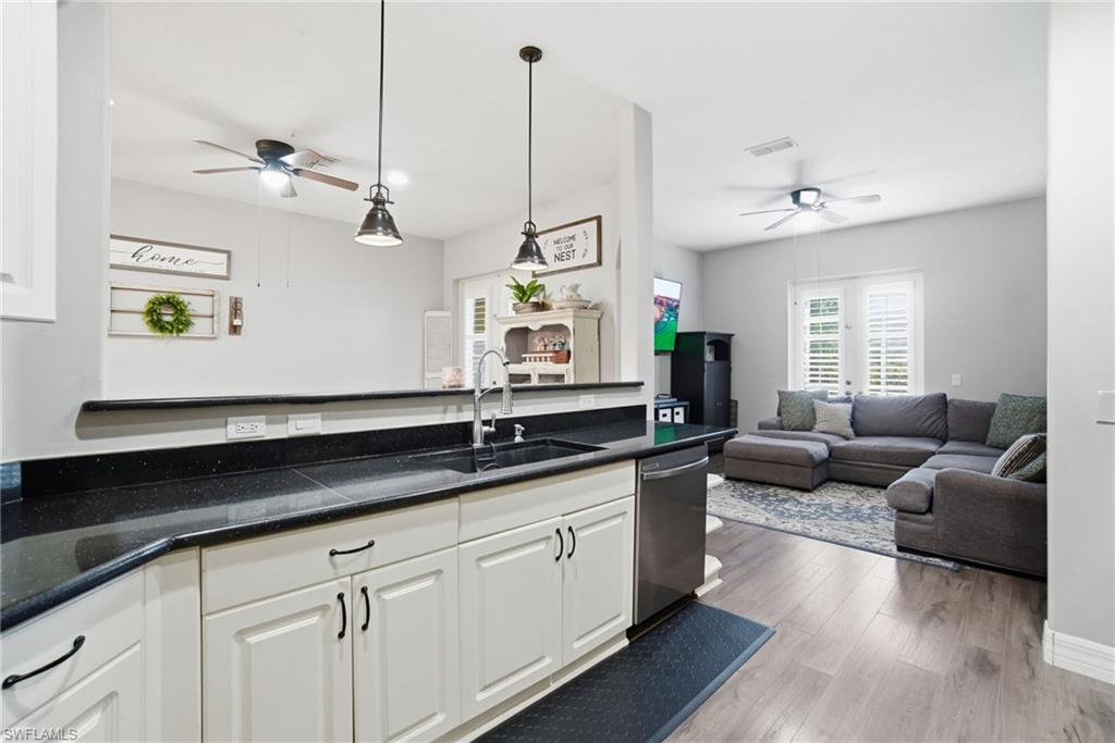 2900 Orange Grove Trail Naples, FL 34120 - Photo 16 of 46 a living room with granite countertop kitchen island white cabinets and wooden floor