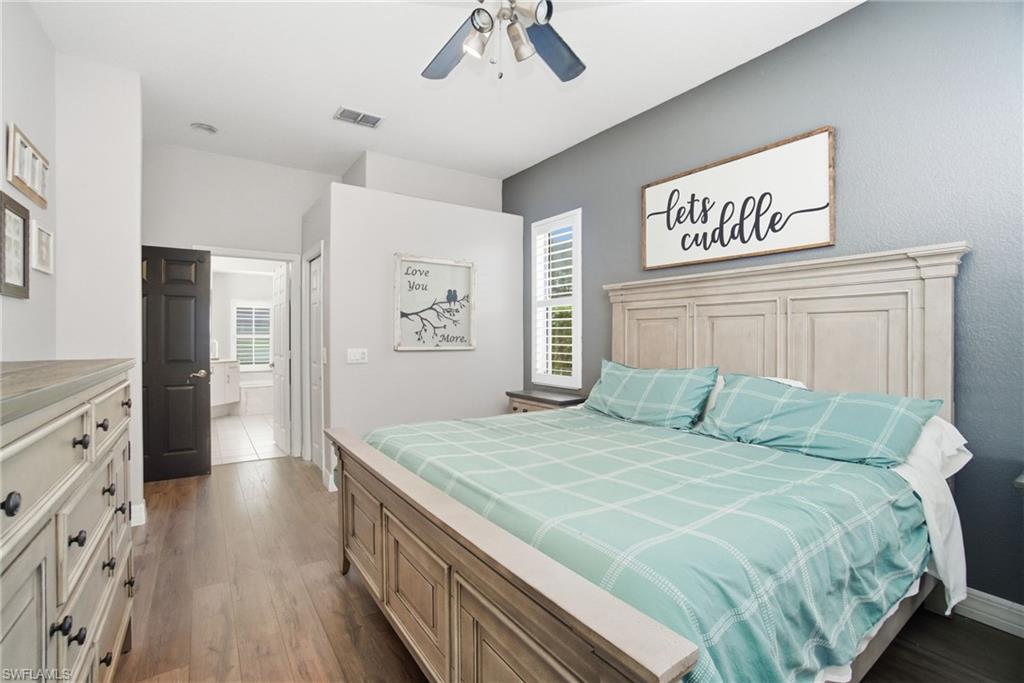 2900 Orange Grove Trail Naples, FL 34120 - Photo 21 of 46 a bedroom with a large bed and a chandelier