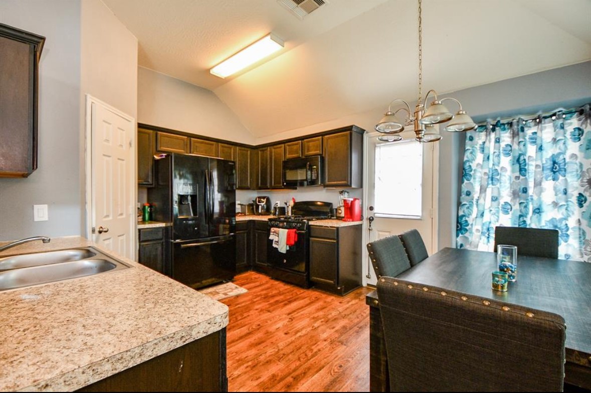 14911 Tranquility Ridge Court Humble, TX 77396 - Photo 4 of 8 a kitchen with kitchen island granite countertop a sink stove and refrigerator