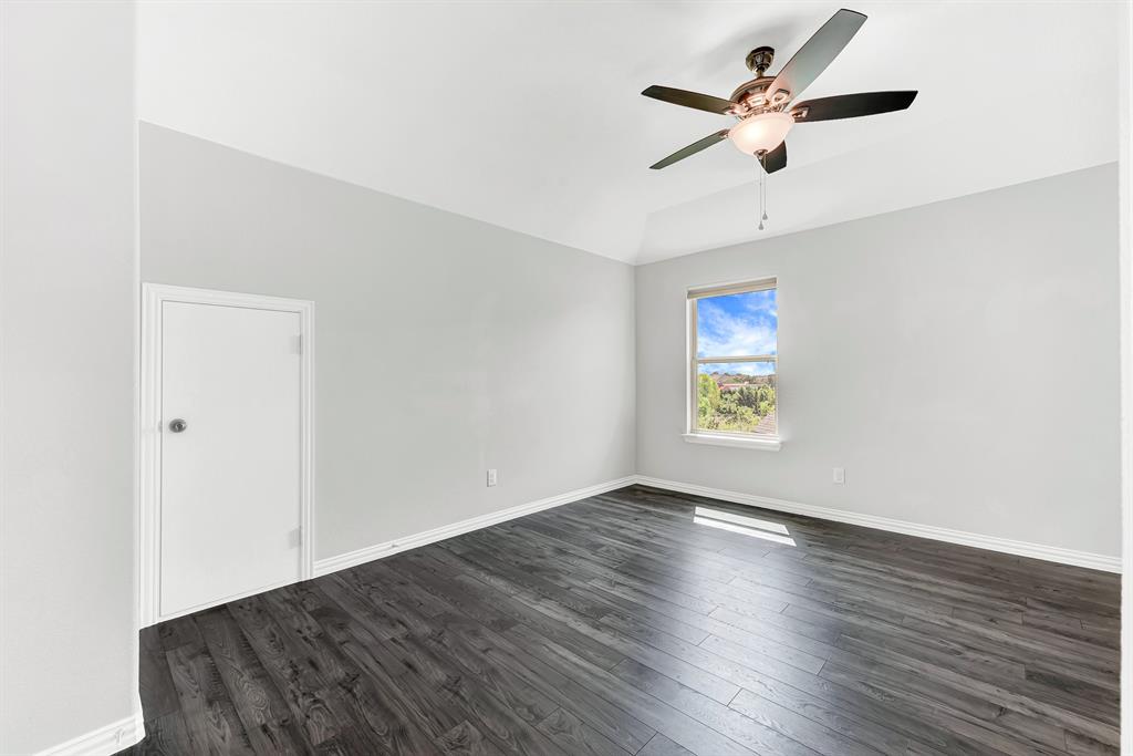 7640 Rhyner Way Fort Worth, TX 76137 - Photo 37 of 40 Dark wood-finish flooring, vaulted ceiling, and a ceiling fan with integrated lighting