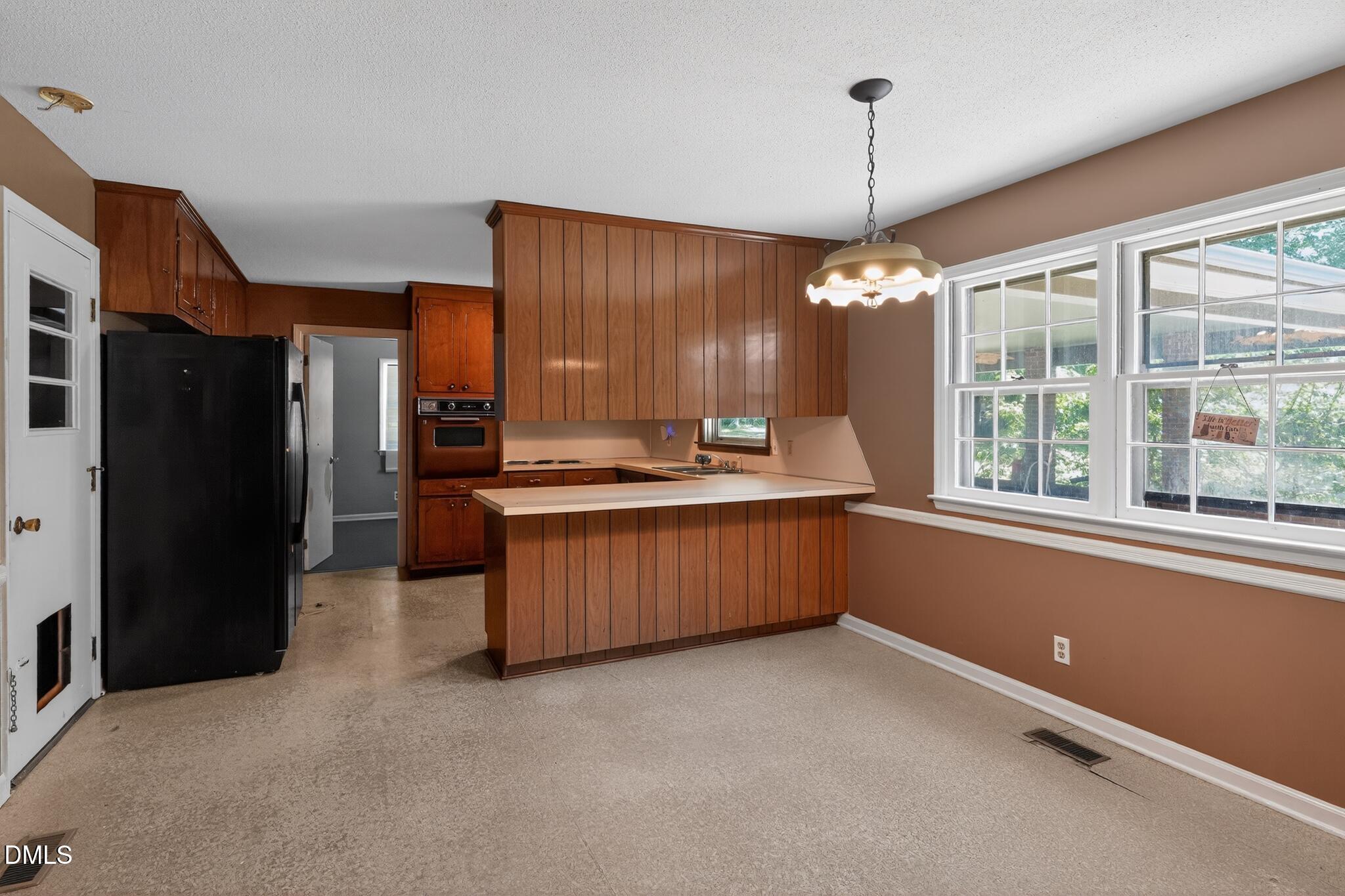 1034 Jerome Road Durham, NC 27713 - Photo 18 of 35 a kitchen with stainless steel appliances kitchen island granite countertop a refrigerator and a sink