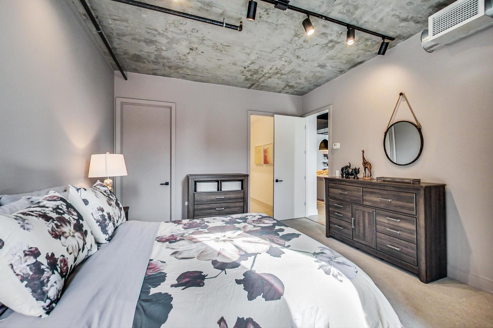 111 South Peoria Street, Unit 309 Chicago, IL 60607 - Photo 31 of 43 a bedroom with a large bed and a chandelier