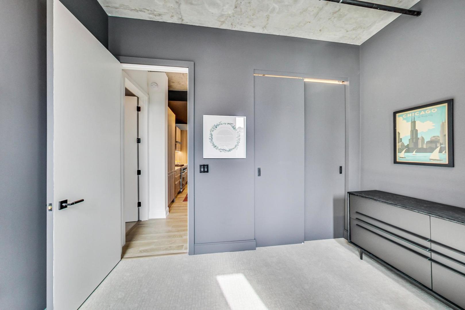 111 South Peoria Street, Unit 309 Chicago, IL 60607 - Photo 36 of 43 a bedroom with a bed and a chandelier