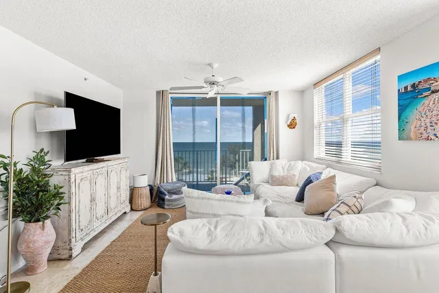 a living room with furniture a dining table and a floor to ceiling window