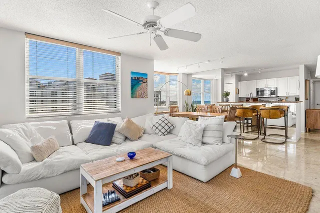 a kitchen with stainless steel appliances kitchen island granite countertop a dining table chairs refrigerator and sink