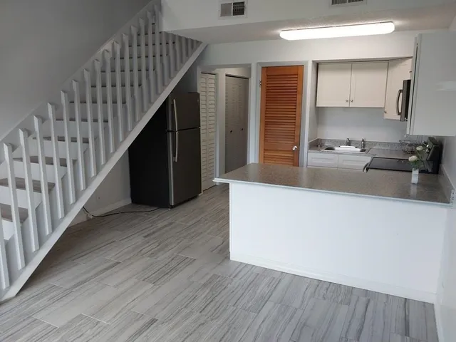 a kitchen with wooden floors and cabinets