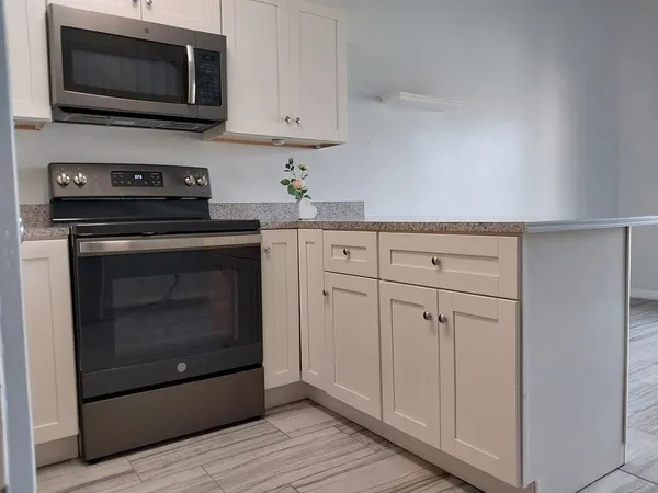 a kitchen with white cabinets stainless steel appliances and sink
