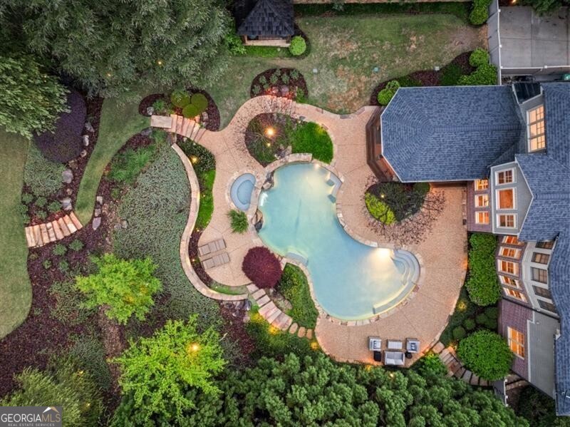 an aerial view of a house with outdoor space and swimming pool
