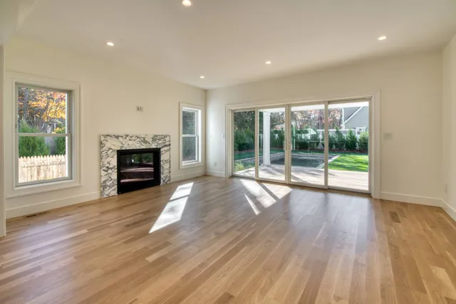 a view of empty room with wooden floor and fireplace