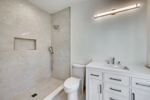a bathroom with a sink a toilet and shower