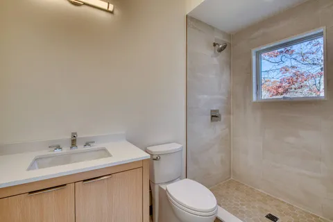 a bathroom with a sink a toilet and shower