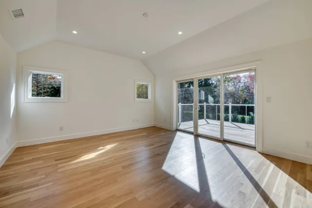 a view of a big room with wooden floor and windows
