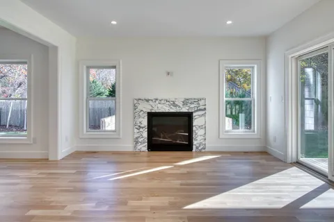 an empty room with floor to ceiling window and fireplace