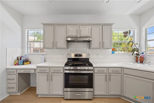 a kitchen with white cabinets and appliances