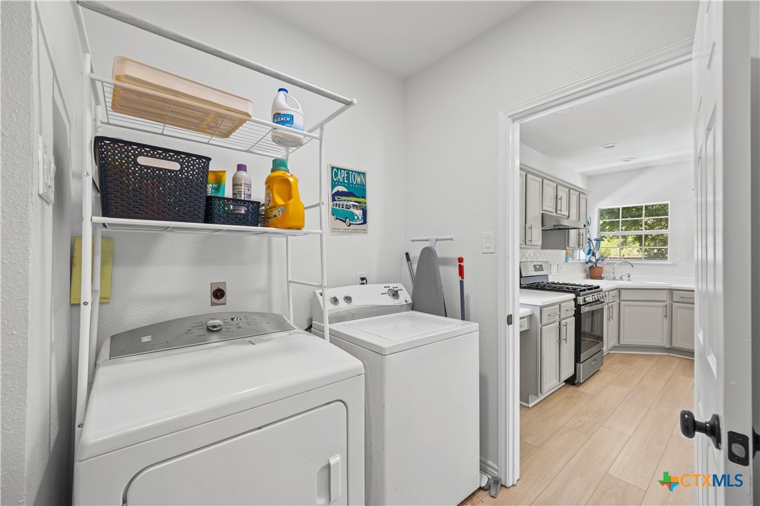1710 Greening Way Leander, TX 78641 - Photo 19 of 47 a view of washer and dryer with kitchen in the background