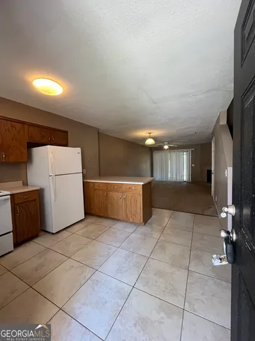 a view of a storage & utility room with a fridge