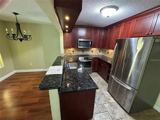 a kitchen with granite countertop stainless steel appliances and wooden cabinets