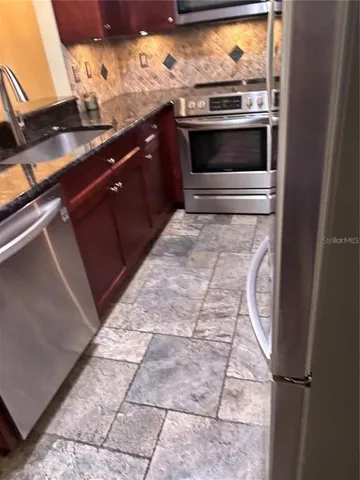 a kitchen with granite countertop a sink and cabinets