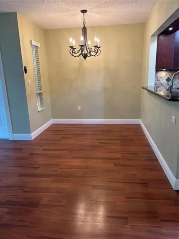 a view of room with hardwood floor and a ceiling fan