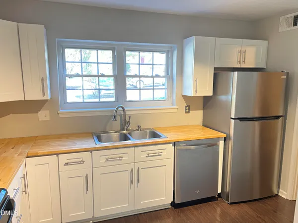 a kitchen with appliances a sink and a window