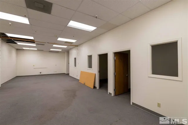 an empty room with closet and mirrors