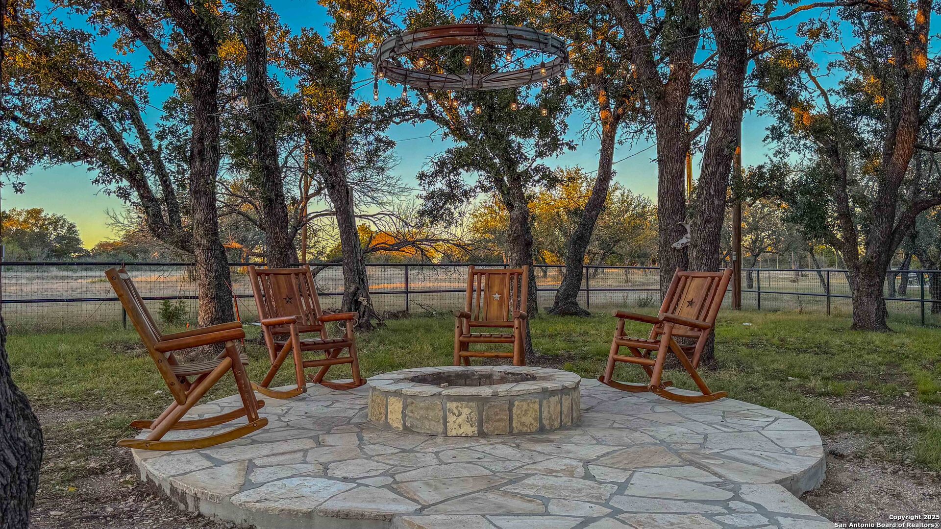 1950 Tolles Road Menard, TX 76859 - Photo 14 of 54 a view of a backyard with table and chairs potted plants and large tree