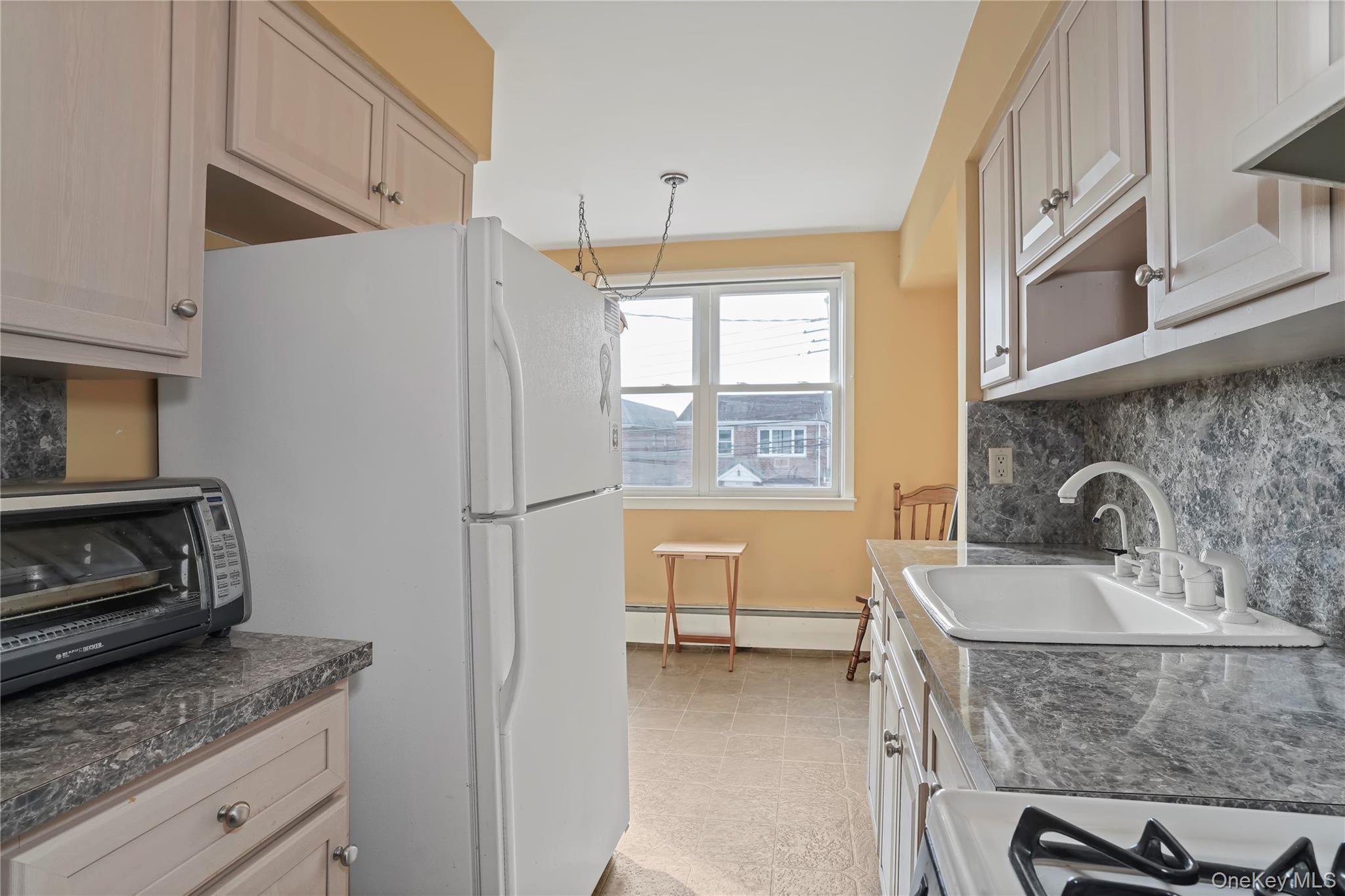 60-35 75th Street Queens, NY 11379 - Photo 19 of 29 a kitchen with stainless steel appliances granite countertop a sink stove and refrigerator