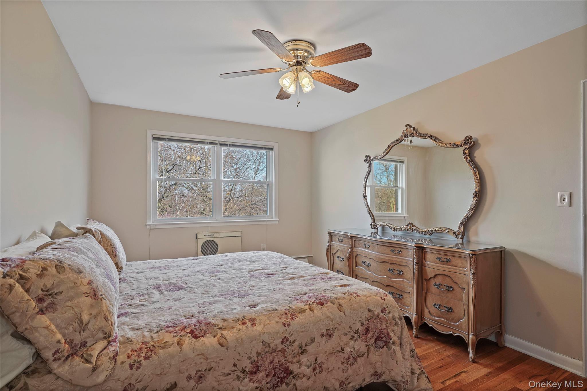 60-35 75th Street Queens, NY 11379 - Photo 21 of 29 a bedroom with a bed a mirror on dresser and a chandelier