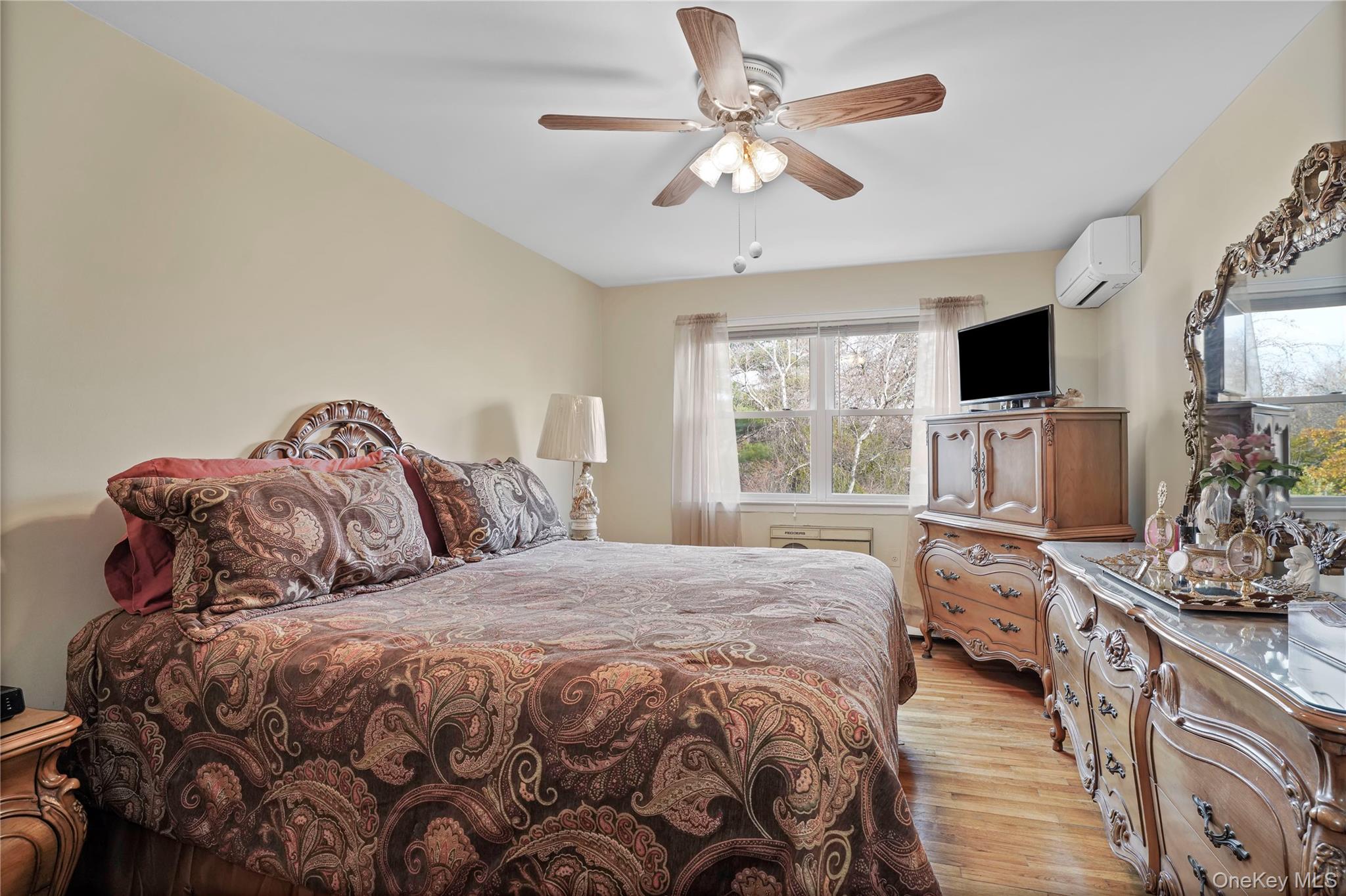 60-35 75th Street Queens, NY 11379 - Photo 9 of 29 a bedroom with a large bed and a flat tv screen on dresser